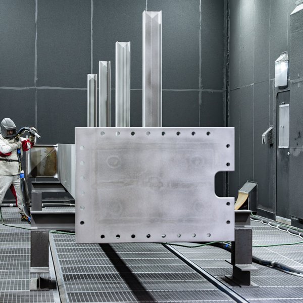 Mitarbeiter bei der industriellen Oberflächenbeschichtung mit moderner Anlagentechnik